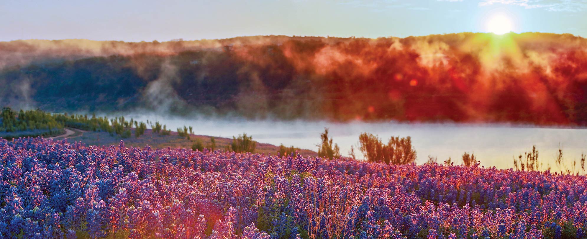 Hills, a lake, and the natural landscape at sunset in Austin, Texas.