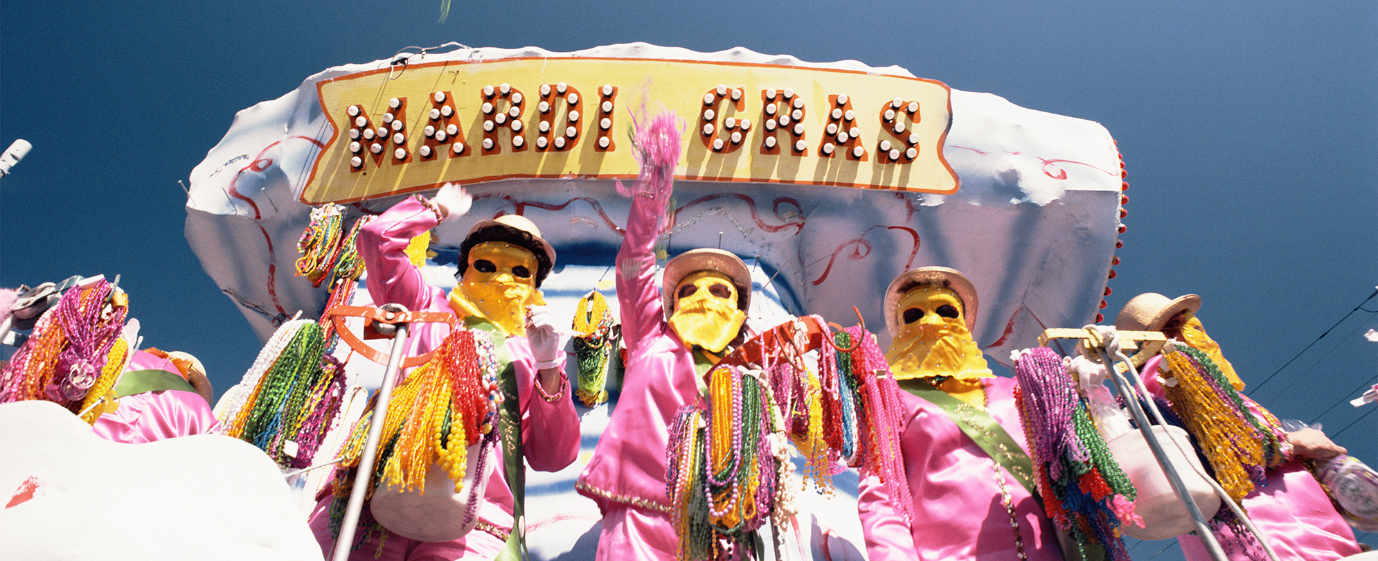 Masked Mardi Gras performers on a float in New Orleans.