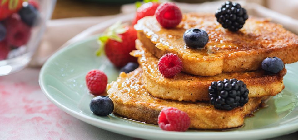 French toast on a plate with raspberries, blueberries, and blackberries at a restaurant in San Francisco, California.