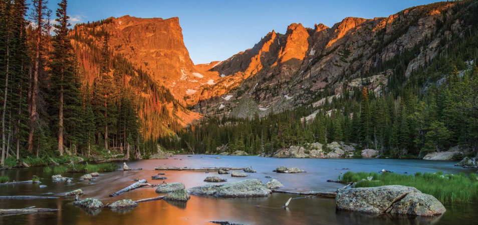 Mountains behind a rocky lake during golden hour at Rocky Mountain National Park in Colorado.