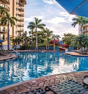 A pool surrounded by chairs and palm trees at WorldMark Palm-Air.