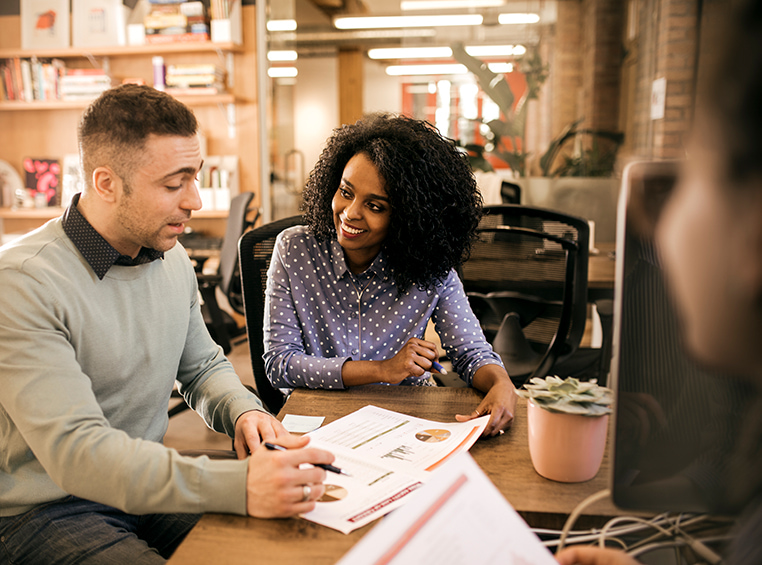 A man from contact title services going over paperwork with a woman. 