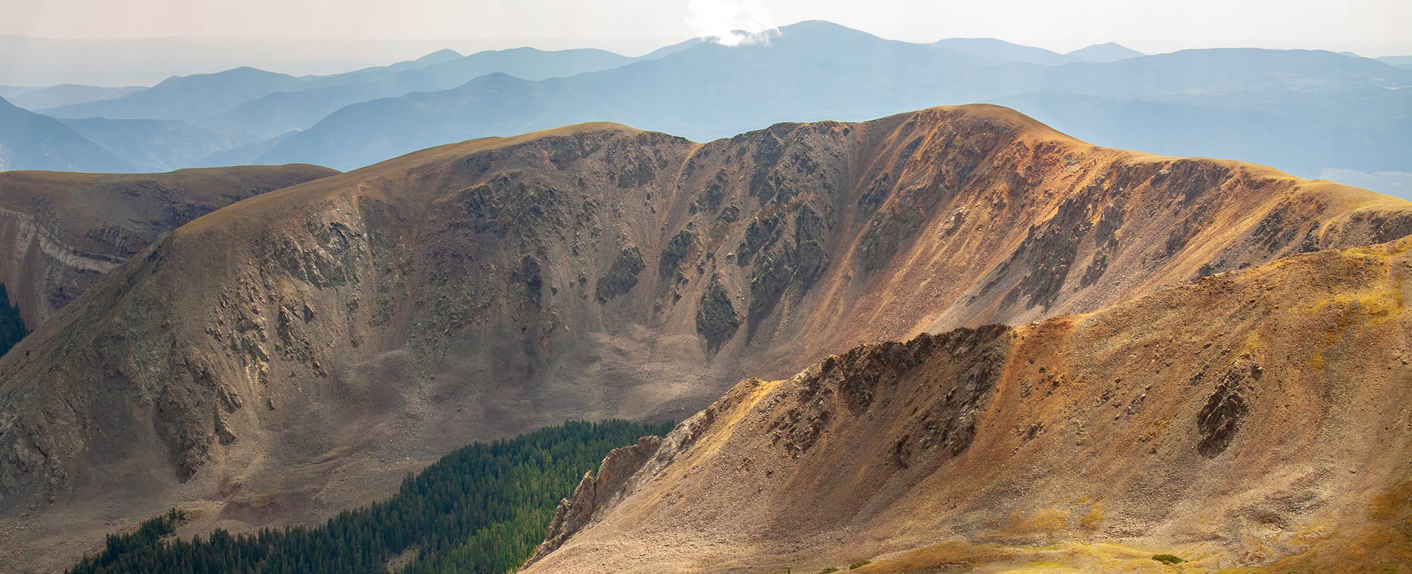 A mountain range with a valley of grass in a New Mexico National Park with WorldMark by Wyndham.