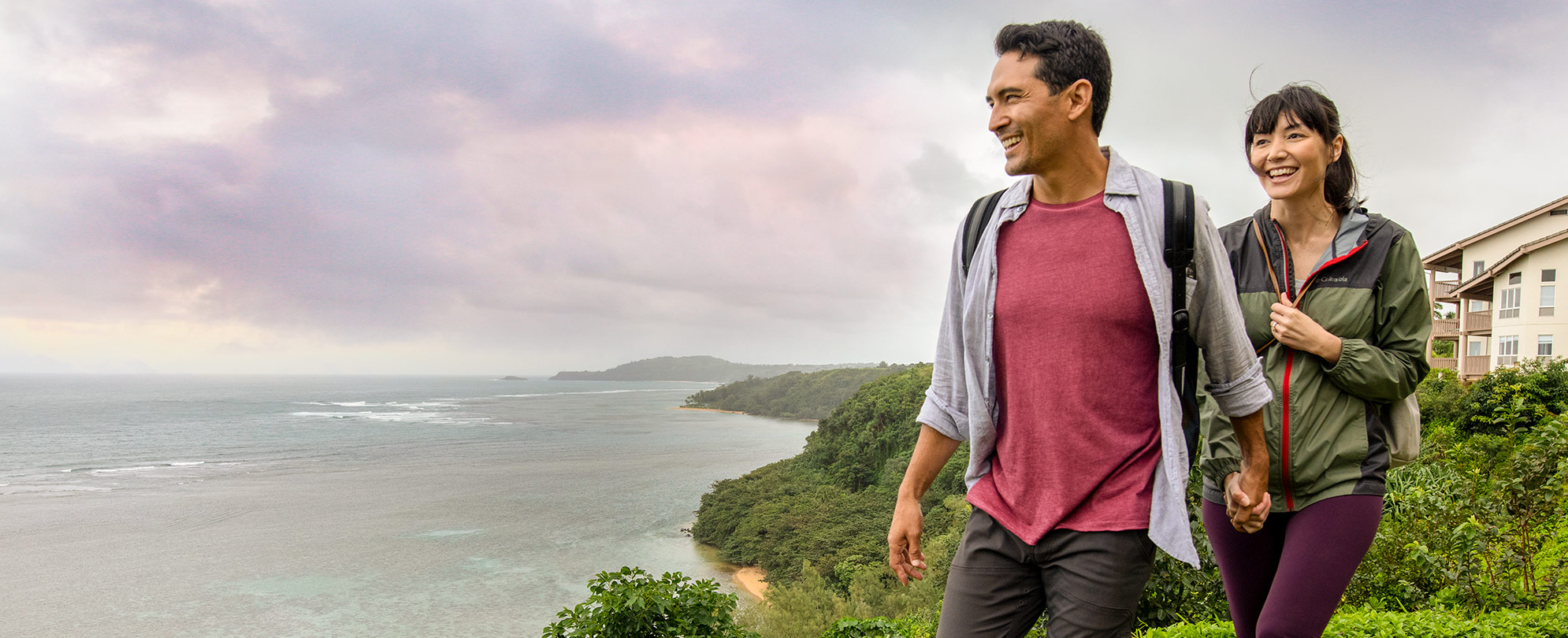 A man and a woman taking a hike along the ocean. 