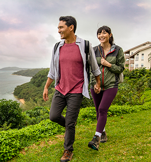 A man and a woman taking a hike along the ocean. 