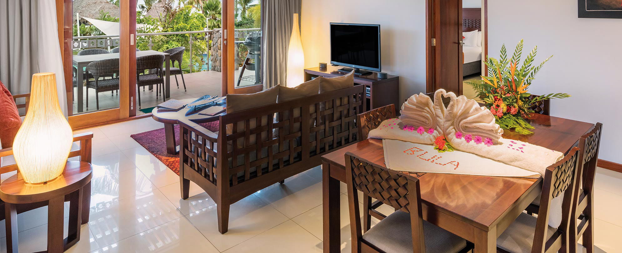 The living room of a WorldMark by Wyndham suite with towels folded to look like swans siting on the table.